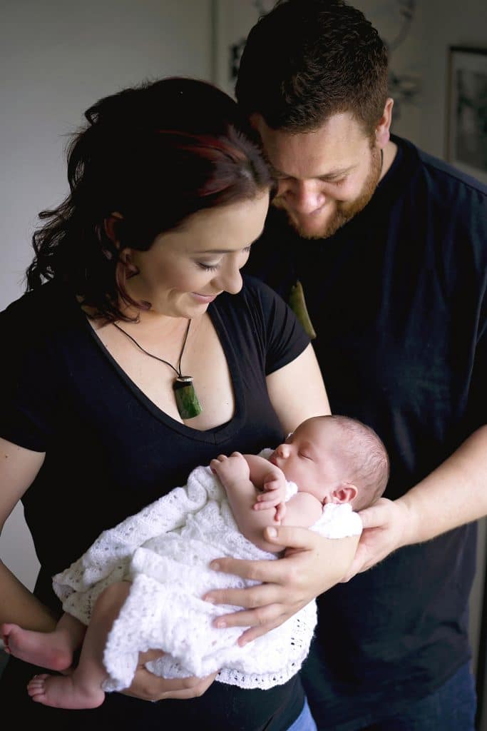 Mum and Dad holding their newborn baby captured by Tauranga newborn photographer Susanna